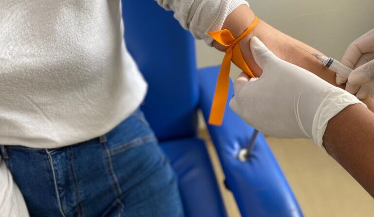 Profissional do Hospital Estadual de Formosa se prepara para colher sangue de paciente. (Foto: Braz da Silva/Imed)