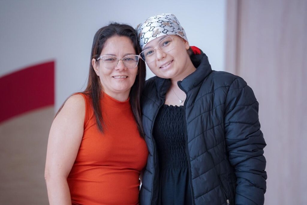 Para pacientes como Yasmin Stephani, de 16 anos, o ambiente lúdico transforma a rotina hospitalar. “Os profissionais são incríveis, levam tudo na brincadeira e isso ajuda muito”. A gente sente até alegria de vir para cá”, conta a jovem, acompanhada da mãe, Wniglei Dias (Fotos: Iron Braz)